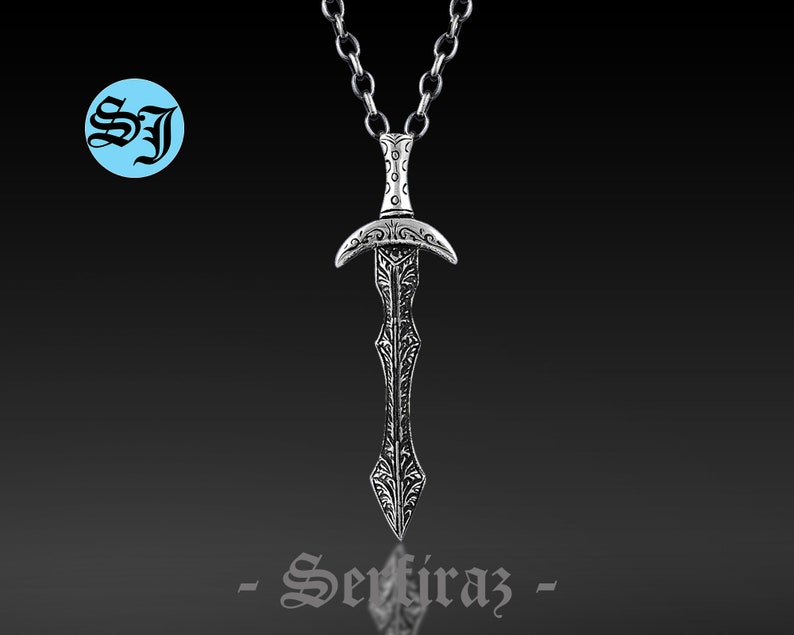 May include: Silver pendant necklace featuring a detailed sword design. The sword has a decorative handle and a pointed blade. The chain is silver and has a classic link style.