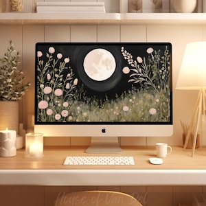 以下が含まれることがあります： 白い背景に満月と暗い空、前景にピンクの花が咲くデスクトップコンピューター。コンピューターは、白いキーボード、白いキャンドル、白いマグカップのある木製デスクの上に置かれています。