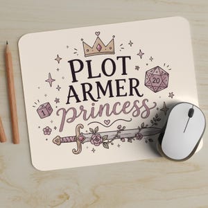 May include: A rectangular mouse pad with a cream background featuring the text PLOT ARMER princess in black and purple. The design includes a crown, a twenty-sided die, a one-sided die, stars, hearts, and a sword wrapped in floral vines.