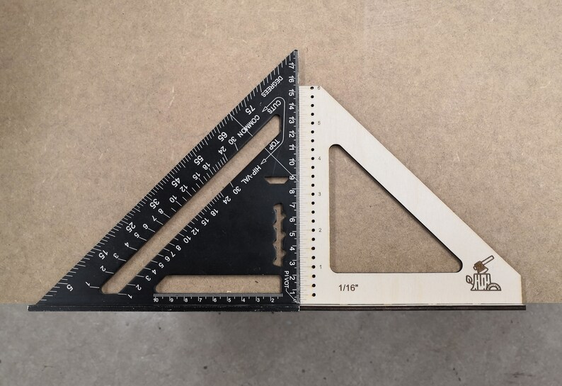 May include: A black and white combination square with markings in inches. The black square has a ruler on two sides and a protractor on the third side. The white square has a ruler on one side and a protractor on the other side. The white square has a small logo of an axe on a tree stump.