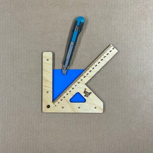 May include: A wooden cutting guide with a blue cutting mat and a utility knife. The guide has a ruler on one side and a protractor on the other.
