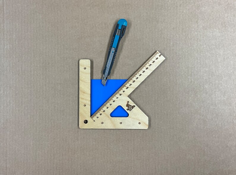 May include: A wooden cutting guide with a blue cutting mat and a utility knife. The guide has a ruler on one side and a protractor on the other.