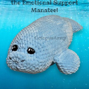 May include: A light blue crocheted manatee plush toy with black eyes. The toy is floating in a blue water background with white sparkles. The text "Manfred the Emotional Support Manatee!" is above the toy and the text "OctopusArmy" is below the toy.
