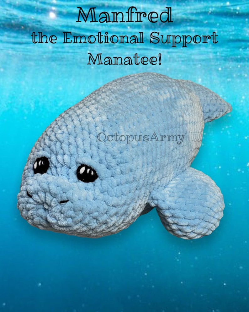 May include: A light blue crocheted manatee plush toy with black eyes. The toy is floating in a blue water background with white sparkles. The text "Manfred the Emotional Support Manatee!" is above the toy and the text "OctopusArmy" is below the toy.