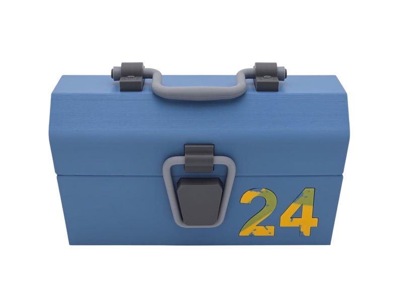May include: A light blue toolbox with a gray handle and clasps. The number "24" is displayed in yellow and green on the front of the box. The toolbox is closed and has a rectangular shape.