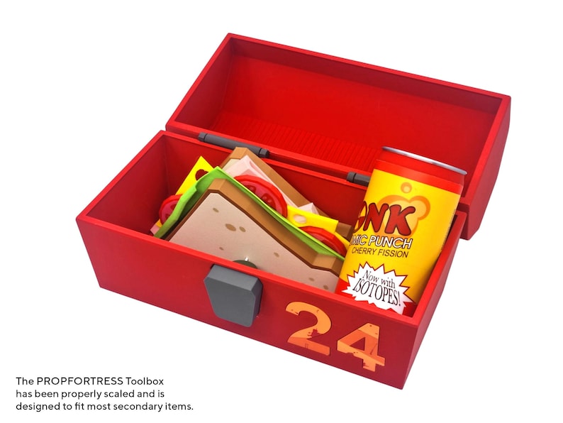 May include: A red toolbox with the number 24 on the side, open to reveal a sandwich and a can of "Bonk! Atomic Punch" cherry fission soda. The toolbox is designed to fit most secondary items.