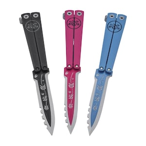 Op de afbeelding: Drie vlindermessen in zwart, roze en blauw. Elk mes heeft een bloemenontwerp op het lemmet en de handgreep. De messen hebben een gekartelde rand. De handgrepen hebben een cirkelvormig ontwerp.