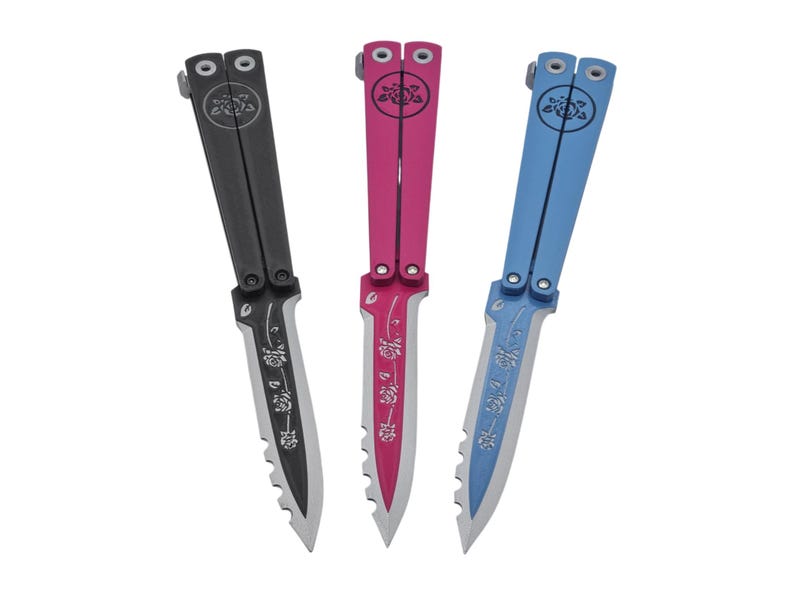 Op de afbeelding: Drie vlindermessen in zwart, roze en blauw. Elk mes heeft een bloemenontwerp op het lemmet en de handgreep. De messen hebben een gekartelde rand. De handgrepen hebben een cirkelvormig ontwerp.