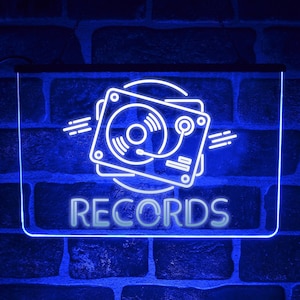 Peut inclure: Enseigne au néon bleue avec un contour blanc d'un tourne-disque et le mot "RECORDS" en lettres blanches.