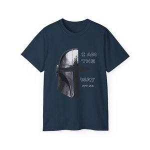 May include: Navy blue t-shirt featuring a graphic of a helmet and the text "I AM THE WAY" with "John 14:6" below. The helmet is a dark gray color. The shirt is a short-sleeved crew neck.