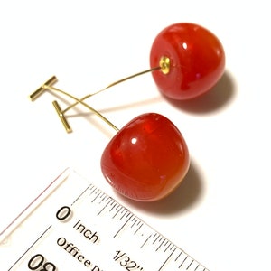 K&ouml;nnte beinhalten: Ein Paar rote Kirsch-Ohrringe mit goldenen Stielen und T-Bar-Verschl&uuml;ssen. Die Kirschen haben einen Durchmesser von etwa 1,25 cm.