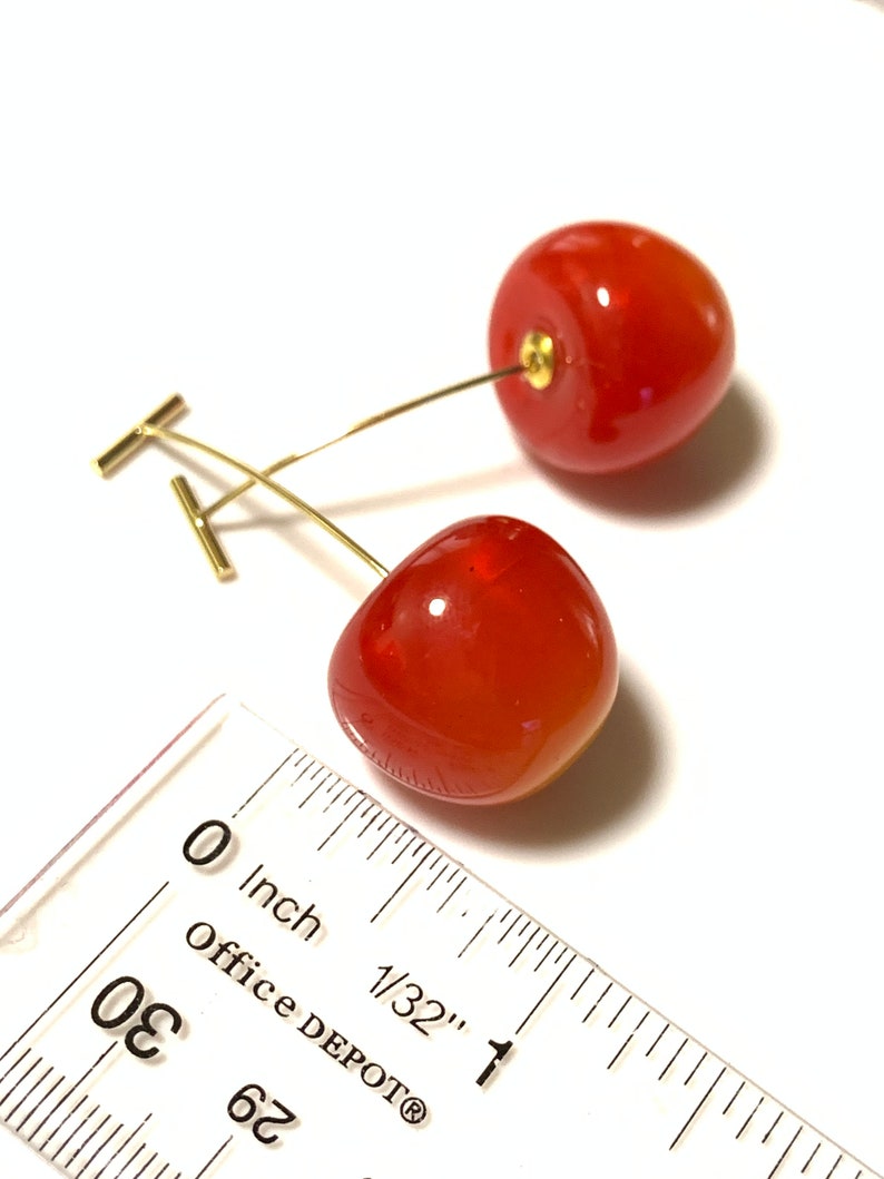 K&ouml;nnte beinhalten: Ein Paar rote Kirsch-Ohrringe mit goldenen Stielen und T-Bar-Verschl&uuml;ssen. Die Kirschen haben einen Durchmesser von etwa 1,25 cm.