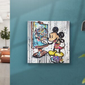May include: A colorful painting of Mickey Mouse painting a portrait of himself on a canvas. The background is white with splashes of paint.