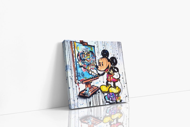 May include: A colorful painting of Mickey Mouse painting a self-portrait on a canvas. The background is white with black splatters of paint. Mickey Mouse is wearing his signature red shorts and yellow shoes.