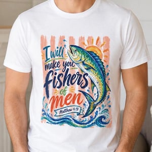 May include: White t-shirt with a vibrant graphic of a fish jumping from water, a sun, and the text "I will make you fishers of men Matthew 4:19". The design incorporates blue, yellow, and orange colours.