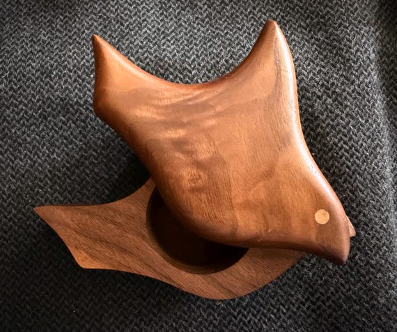 A 1970s hand-carved biomorphic wooden bird that's secretly a puzzle box — sculptural mid-century art object AND a hidden stash compartment in one.