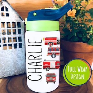 May include: White stainless steel water bottle with a green lid and blue spout. The bottle has a black and white design of the name "CHARLIE" and four red fire trucks. The text "FULL WRAP DESIGN" is on a green circle.
