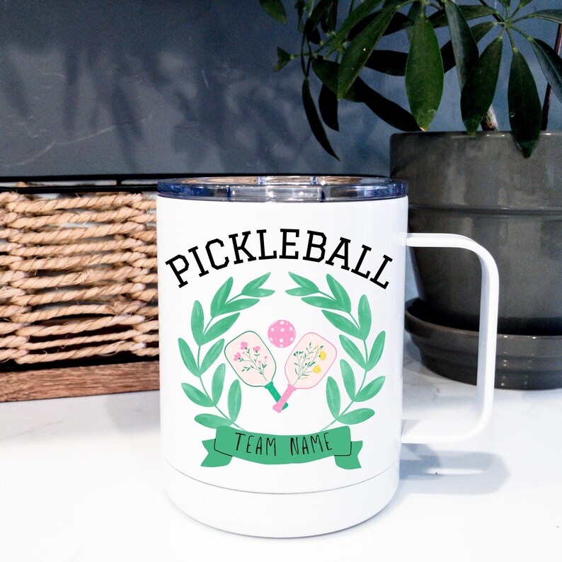 May include: White travel mug with a green and pink pickleball paddle design and the text "Pickleball Team Name".