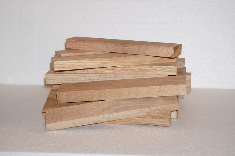 May include: A stack of unfinished, light brown wooden planks. The planks are approximately 1 inch thick and 12 inches long.