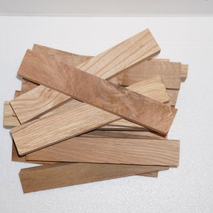 May include: A pile of light brown wood blanks, likely for woodworking projects. The wood has a natural grain pattern and is ready to be shaped and finished.
