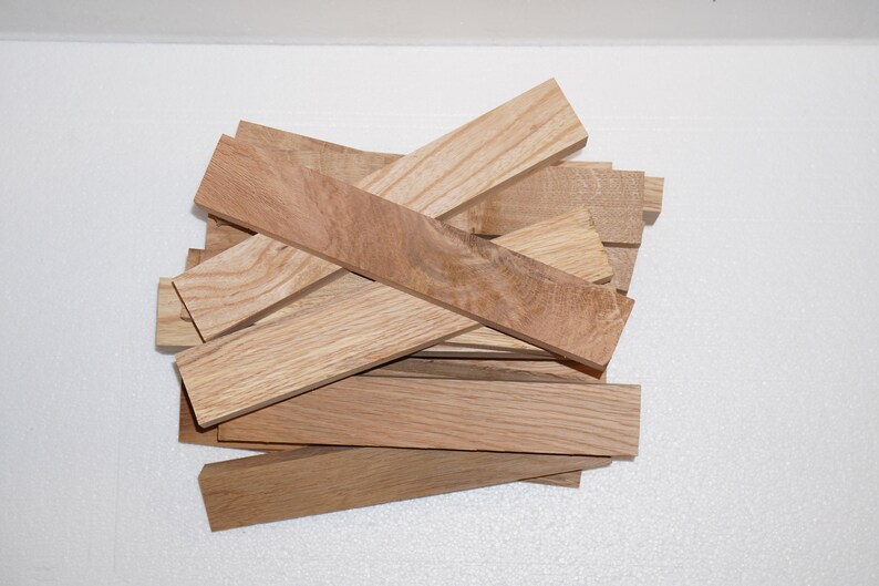 May include: A pile of light brown wood blanks, likely for woodworking projects. The wood has a natural grain pattern and is ready to be shaped and finished.