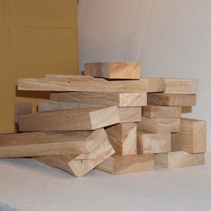 May include: A pile of unfinished, light brown wooden planks, likely for woodworking projects.