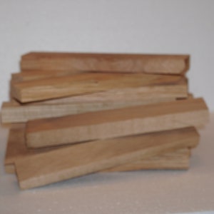 May include: A stack of wooden blocks, likely for woodworking or crafts. The blocks are a light brown color and have a smooth, polished finish.