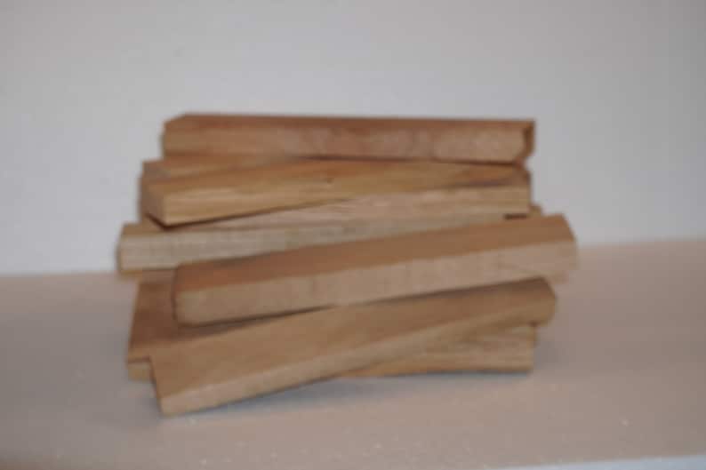 May include: A stack of wooden blocks, likely for woodworking or crafts. The blocks are a light brown color and have a smooth, polished finish.