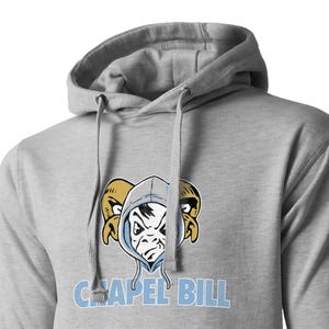 May include: Gray hooded sweatshirt with a cartoon mascot wearing a hooded sweatshirt. The mascot has a blue face with a yellow and black horned helmet. The text "CHAPEL HILL" is printed in blue below the mascot.