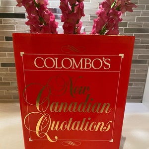 Könnte beinhalten: Ein rotes Hardcover-Buch mit dem Titel "Colombo's New Canadian Quotations" von John Robert Colombo.