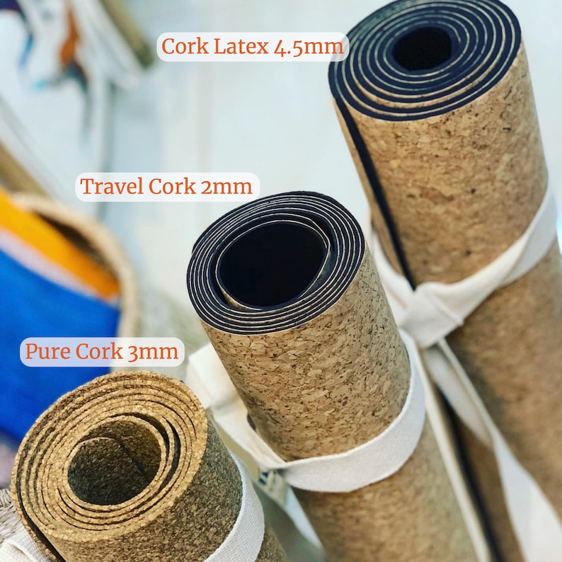 Pode incluir: Tr&ecirc;s tapetes de ioga enrolados com superf&iacute;cies de corti&ccedil;a. Os tapetes s&atilde;o etiquetados como "Cork Latex 4,5 mm", "Travel Cork 2 mm" e "Pure Cork 3 mm".