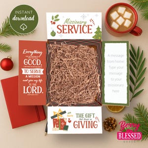 以下が含まれることがあります： 「Missionary Service」と「The Gift that keeps on Giving」の文字が入ったギフトボックス。ボックスには細かく刻まれた紙と赤いノートが入っています。マシュマロが入ったホットチョコレートのカップも見えます。