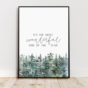 Könnte beinhalten: Ein druckbarer Kunstdruck mit weißem Hintergrund und schwarzem Text, der "Es ist die schönste Zeit des Jahres" lautet. Der Text ist in einer kursivschriftlichen Schriftart. Der untere Teil des Drucks zeigt eine Aquarellillustration eines schneebedeckten Waldes mit grünen Kiefern.