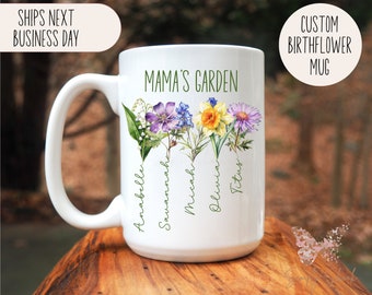 May include: White ceramic mug with a floral design and the text "Mama's Garden." The mug features colorful watercolor flowers and names. The mug also has the text "Custom Birthflower Mug."