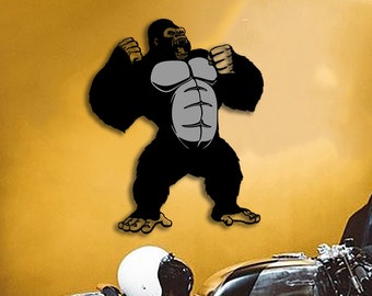 May include: A black and white illustration of a gorilla with its arms raised in a powerful pose. The illustration is mounted on a wall behind a black and silver motorcycle.