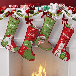 May include: Four personalized Christmas stockings with red and green fabric and different animal designs. The stockings are hung on a white mantel with a lit fireplace below. The stockings are labeled "Ellie", "Jacob", "Mason", and "Sophia".