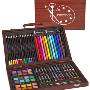 May include: A wooden art set with a personalized name "Jonathan" on the lid. The set includes colored pencils, markers, crayons, watercolor paints, and an eraser.
