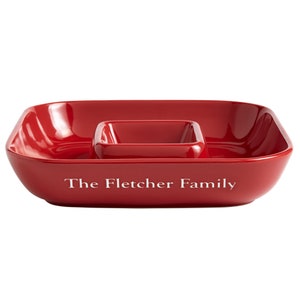 K&ouml;nnte beinhalten: Eine rote Keramik-Servierplatte mit einer kleineren, quadratischen Schale in der Mitte. Die gr&ouml;&szlig;ere Schale tr&auml;gt die Aufschrift "The Fletcher Family" auf der Vorderseite.