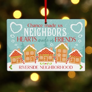 May include: A rectangular Christmas ornament with a light blue background and the text "Chance made us NEIGHBORS, HEARTS made us FRIENDS." Features gingerbread houses, candy canes, and the words "RIVERSIDE NEIGHBORHOOD."