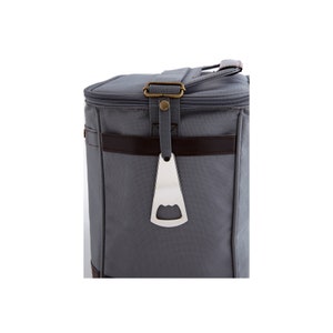 Pu&ograve; includere: Una borsa termica in tela grigia con rifiniture in pelle marrone e un apribottiglie integrato.
