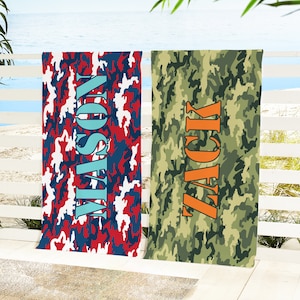 May include: Two beach towels with a camouflage pattern. One towel is red, white, and blue with the name "Wilson" in turquoise. The other towel is green and brown with the name "Jack" in orange.