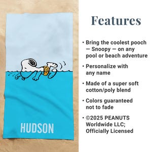May include: A blue and white beach towel featuring Snoopy swimming in water. The towel has the name "HUDSON" printed in white at the bottom. The text "Features" and other details are on the right side.