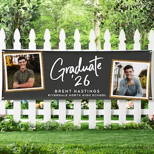 May include: A black graduation banner with the word "Graduate '26" in white script, flanked by two framed photos of a smiling person. The banner also includes the graduate's name and high school.