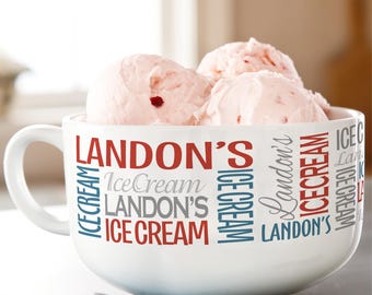 Könnte beinhalten: Eine weiße Keramikschale gefüllt mit Kugeln rosa Eiscreme. Die Schale hat einen Griff und ist mit den Worten "LANDON'S Ice Cream" in roter, blauer und grauer Schrift verziert. Ein Löffel und ein blaues Tuch befinden sich im Vordergrund.