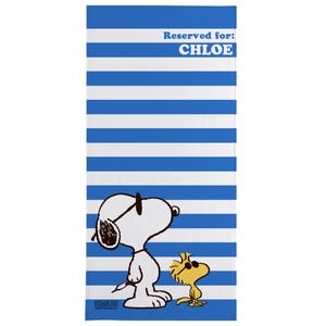 Puede incluir: Una toalla de playa a rayas azules y blancas con el texto "Reservado para: CHLOE" en la parte superior. Snoopy y Woodstock est&aacute;n en la parte inferior de la toalla. Snoopy lleva gafas de sol y Woodstock mira hacia la derecha.