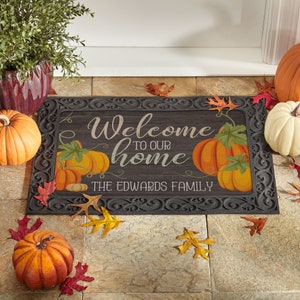May include: A welcome mat with a fall theme featuring pumpkins and leaves. The mat has a black background with a white border and the text "Welcome to our home The Edwards Family".