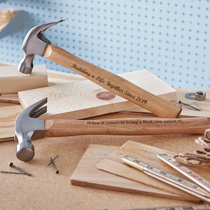 May include: Two wooden-handled hammers with personalized engravings. The top hammer reads "Building a Life Together Since 2019". The bottom hammer reads "When it comes to being a Dad, you nailed it!"