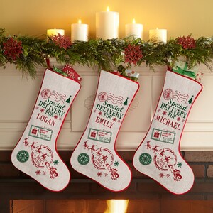 May include: Three personalized Christmas stockings with red and white trim. Each stocking features a green and white design with the text "Special Delivery For" and a name. The names are Logan, Emily, and Michael.