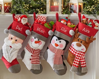 May include: Four personalized Christmas stockings with different character faces. The stockings are red with gray trim and have the names "Dad", "Mom", "Ellie", and "Alex" embroidered on them.