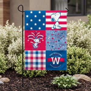 May include: A rectangular garden flag featuring a six-panel patchwork design with red, white, and blue colors. It displays Snoopy, fireworks, stars, and a plaid pattern. The text reads THE WILLIAMS, W, and HAPPY FOURTH OF JULY on a blue background.